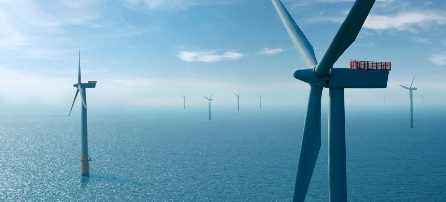 White large offshore wind turbines in the spinning in the ocean.